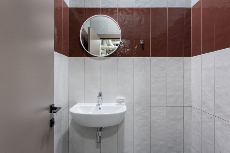 Saubere Sanitaeranlage mit Waschbecken und Spiegel