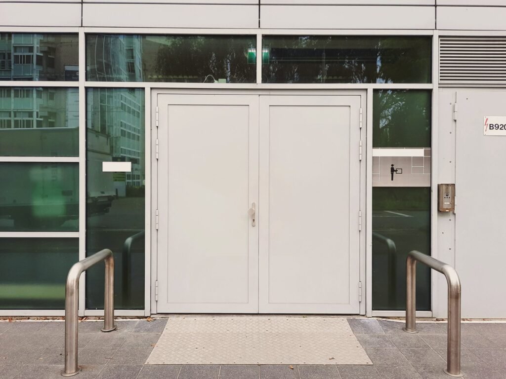 Symmetrisches weißes Glasportal an einer modernen Fassade