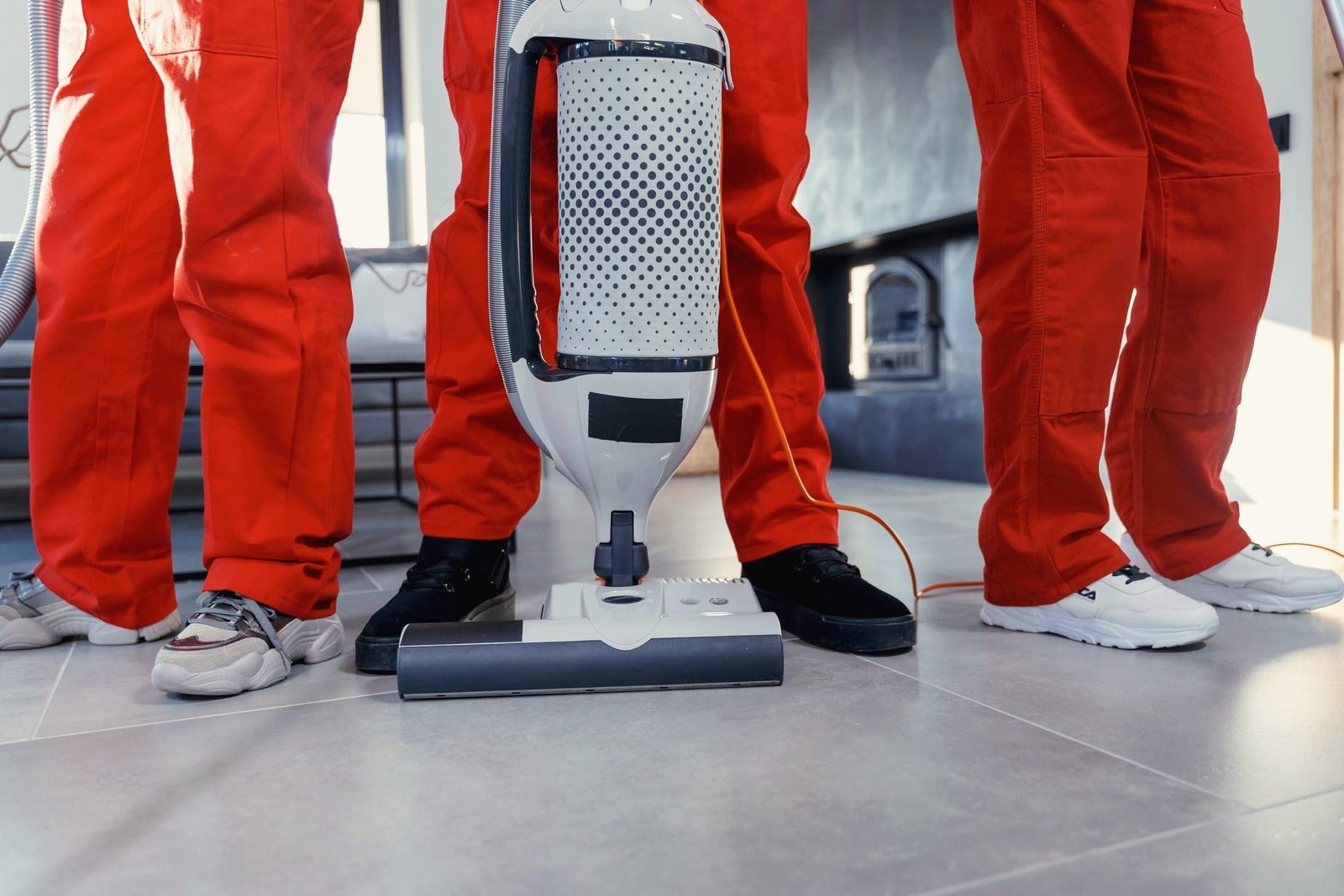 Reinigungsteam in Arbeitskleidung mit Sauger