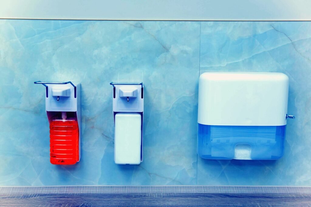 Seifenspender und Papierhandtuchspender an einer hellen Wand
